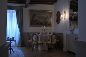 A dining room with a table set for four, a chandelier, and a painting on the wall. - At Handel's Refreshment House (Vignanello)