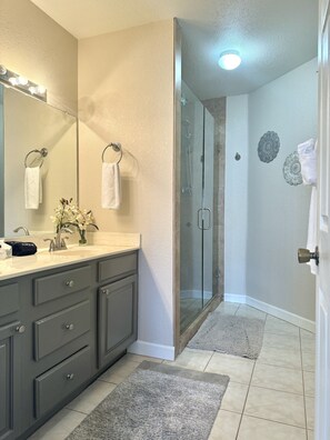 Enjoy a refreshing shower in the bathroom with a sink and glass-enclosed shower.