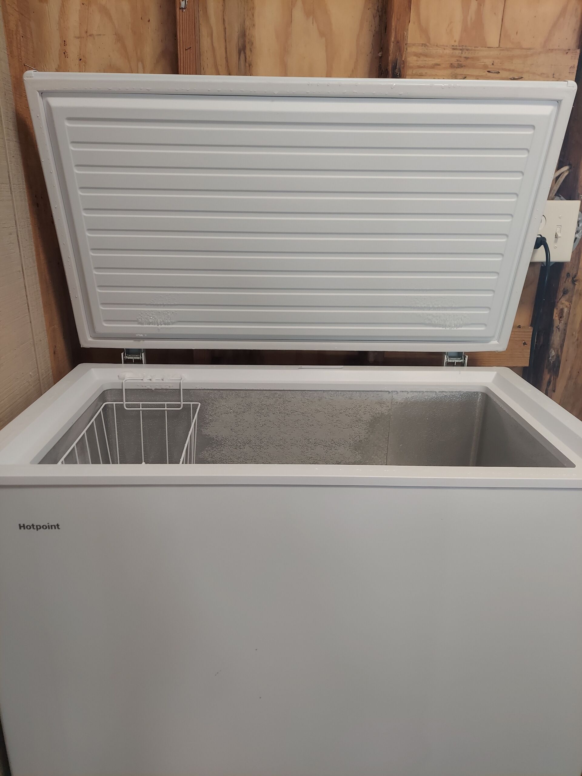 Un réfrigérateur blanc de la marque Hotpoint, doté d’un compartiment congélateur.