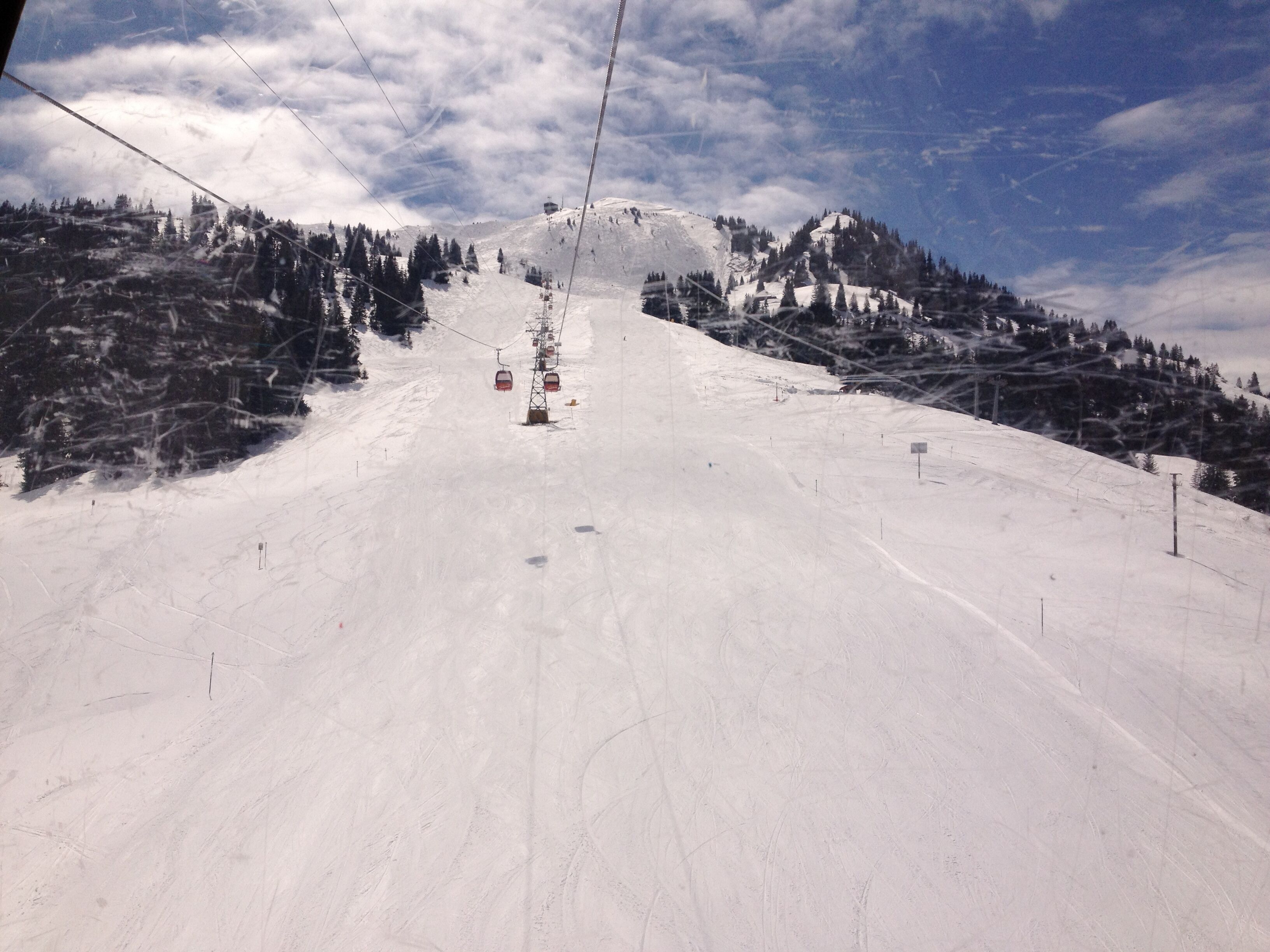 Una pista de esquí nevada con un telesilla y árboles.