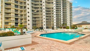 Un hôtel de grande hauteur doté de nombreux balcons, d’une piscine et d’un patio aménagé.