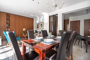 Een moderne eetkamer met een houten tafel voor vier personen, omringd door lederen stoelen.