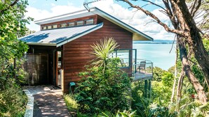 Une maison moderne avec une façade en bois, un balcon et une vue sur la mer.