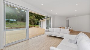 A modern living room with a large sliding glass door leading to an outdoor deck.