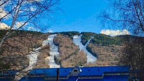 Un edificio con techo azul, rodeado de nieve y árboles.