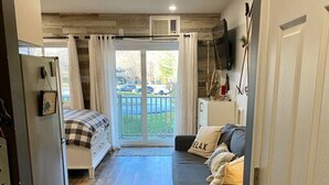 Un espacio habitable compacto con cama, sofá y una pequeña cocina.