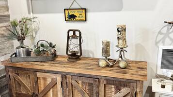 Een rustieke houten console met een tv, decoratieve objecten en een bord erboven.
