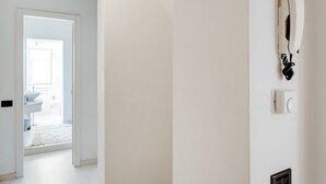 Un pasillo con una puerta blanca que da a un baño.