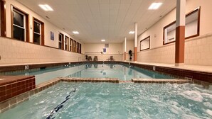 Una piscina interior con carriles delimitados, paredes y suelo de azulejos.