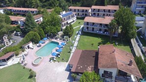 Un hotel amb diversos edificis, una piscina i zones d'estar a l'aire lliure.