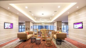 A spacious lobby with a modern design, featuring sofas, chairs, and a central light fixture. - Ramada by Wyndham Meridin Johor Bahru (Iskandar Puteri)