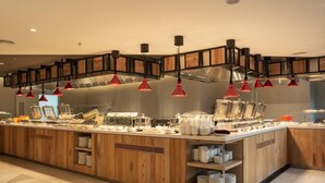 A buffet area with wooden cabinetry, red pendant lighting, and a variety of dishes and utensils. - Ramada by Wyndham Meridin Johor Bahru (Iskandar Puteri)