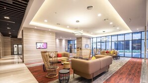 A modern hotel lobby with a spacious seating area, large windows, and a contemporary design. - Ramada by Wyndham Meridin Johor Bahru (Iskandar Puteri)