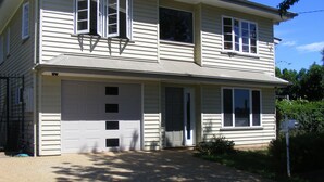A two-story house with a garage, large windows, and a driveway.
