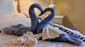 Una camera d'albergo con un letto, una lampada da comodino e un punto luce a parete.