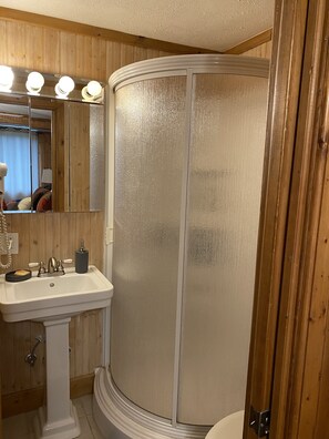 Een bad/douchecombinatie, een haardroger, handdoeken, toiletpapier