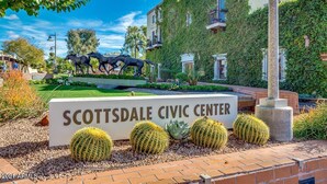 El letrero del Centro Cívico de Scottsdale, con una escultura de caballos y cactus en primer plano.