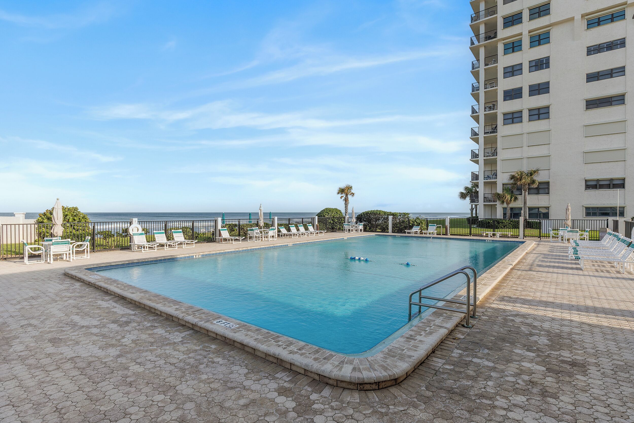 Una piscina amb gandules i vista a l'oceà.