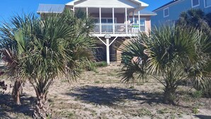 A two-story house with a balcony, surrounded by palm trees. - San Bel - Second row in Garden City Beach (Garden City)