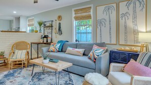 A living room with a sofa, chairs, a coffee table, and a ceiling fan.