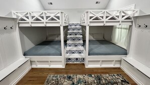 A room with bunk beds, a patterned rug, and a ceiling fan. - Bright stylish home minutes to downtown! New build with HUGE pool/hot tub combo! (Chattanooga)