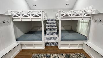 Ein Zimmer mit Etagenbetten, einem gemusterten Teppich und einem Deckenventilator.