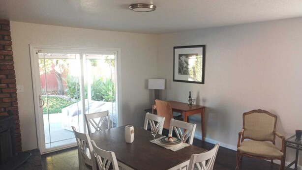 A dining area with a table and chairs, a fireplace, and a door leading to a patio.