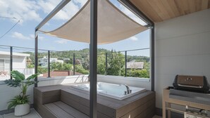 A rooftop terrace with a hot tub, a grill, and a view of the surrounding area. - Shimakaji Villa Onna (Onna)