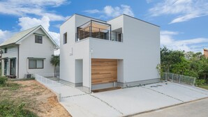 A modern two-story house with a flat roof, a wooden deck, and a white exterior. - Shimakaji Villa Onna (Onna)
