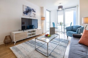 Relax in this stylish living room with a flat-screen TV, comfortable sofa, and city views.