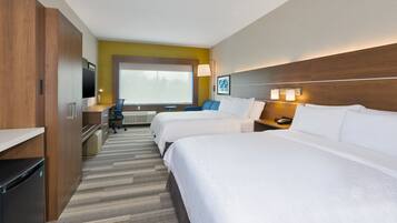 A hotel room with two beds, a desk, a chair, a TV, and a large window.