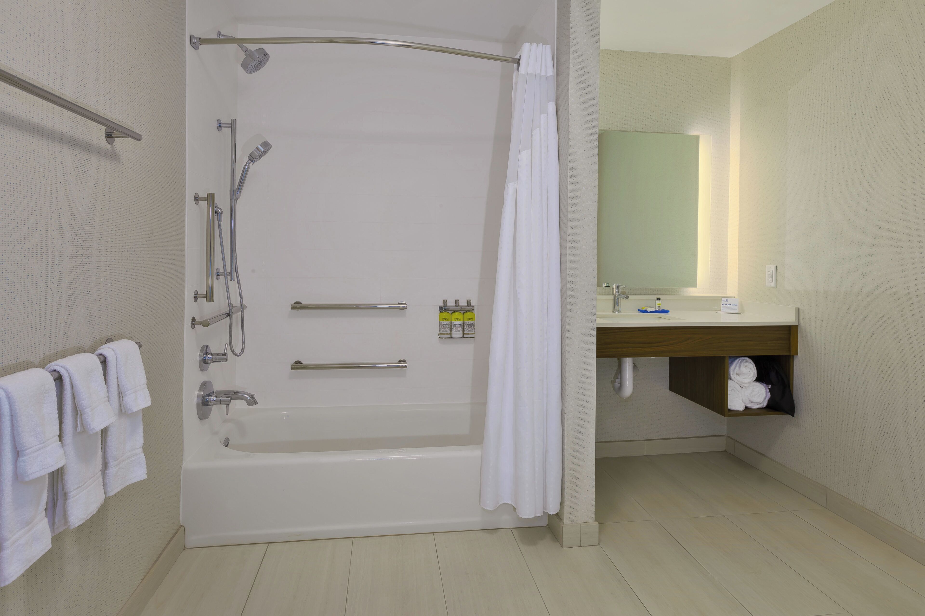 A modern bathroom with a bathtub, shower, and a vanity with a mirror.
