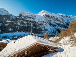 Escape to a serene mountain retreat surrounded by a frozen lake and dense forest.