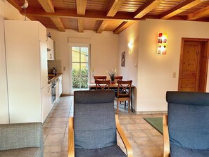 Un intérieur chaleureux comprenant un coin repas, une cuisine et un espace salon.