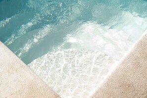 A clear view of a swimming pool with a textured floor and a visible water pattern. - TORRINHA F - Charming studio located in the artistic district of Miguel Bombarda (Porto)