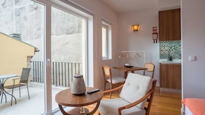 Ett kompakt bostadsutrymme med en balkong, ett matområde och ett kök.