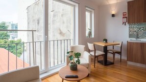 A modern apartment with a balcony, a dining area, and a kitchen. - TORRINHA H - Charming studio located in the artistic district of Miguel Bombarda (Porto)