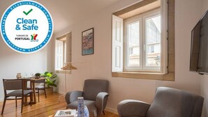 Un soggiorno moderno con zona pranzo, un'ampia finestra e un cartello con la scritta "Clean & Safe".