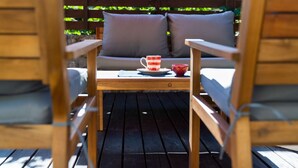 Una terraza de madera con una mesa y dos sillas.