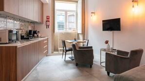 Una cocina moderna con armarios de madera, un comedor con mesa y sillas, y un televisor montado en la pared.