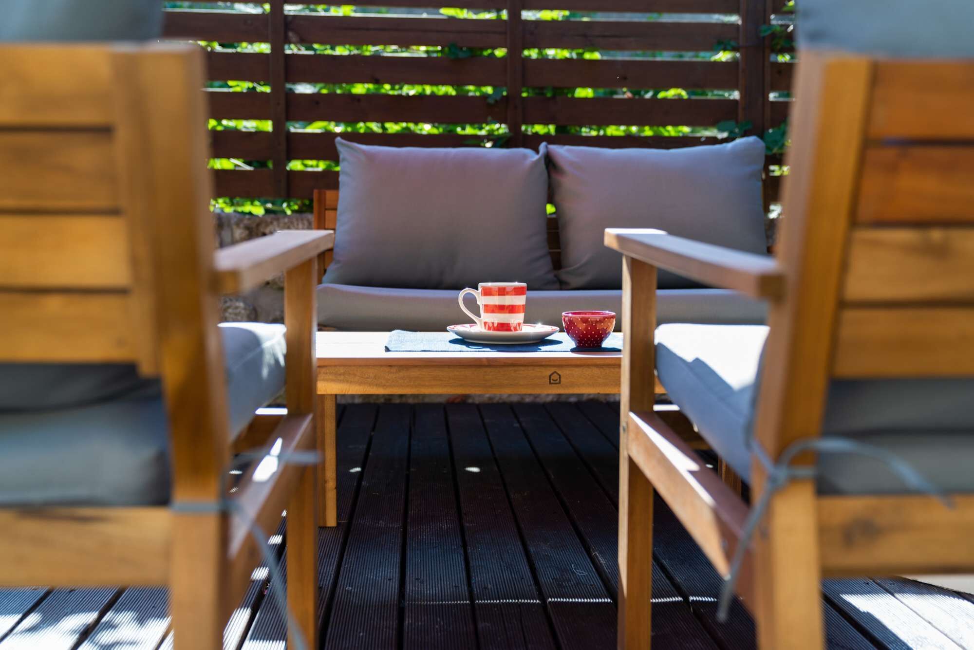 Une terrasse en bois avec une table et deux chaises.