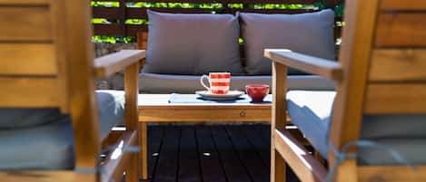 Une terrasse en bois avec une table et deux chaises.