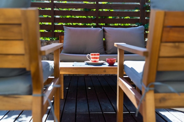 A wooden deck with a table and two chairs.