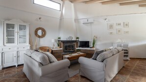 A living room with a fireplace, a television, and a white cabinet. - Holiday Home “Villa Damian” with Mountain View and Garden (Málaga)