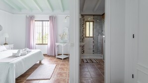 A bedroom with a bed, bedside table, and window with curtains. - Holiday Home “Villa Damian” with Mountain View and Garden (Málaga)