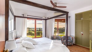 A bedroom with a large bed, a chair, a wardrobe, and a view of the outdoors. - Villa Bon Viure with Sea View, Wi-Fi, Air Conditioning, Pool, Garden & Terraces; Parking Available (Marratxí)