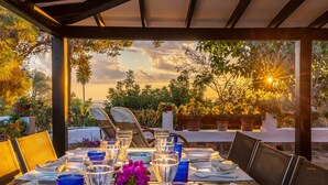 An outdoor dining area with a table set for two, surrounded by chairs, and a view of trees and the sky. - Villa Bon Viure with Sea View, Wi-Fi, Air Conditioning, Pool, Garden & Terraces; Parking Available (Marratxí)