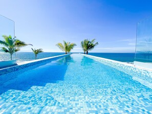 Utendørsbasseng, et evighetsbasseng og solsenger