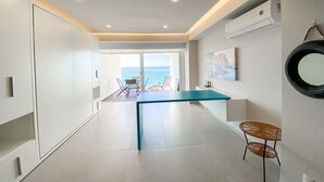 A modern kitchen with a central island, a dining area with chairs, and a view of the sea. - L'Armatore LOFT"- Italian Style (Puerto Vallarta)