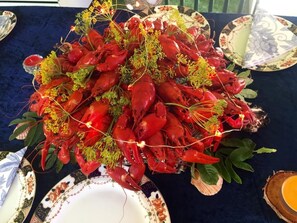 A table with a large arrangement of red crayfish garnished with greenery. - Captivating 1-bed Studio (Avesta)